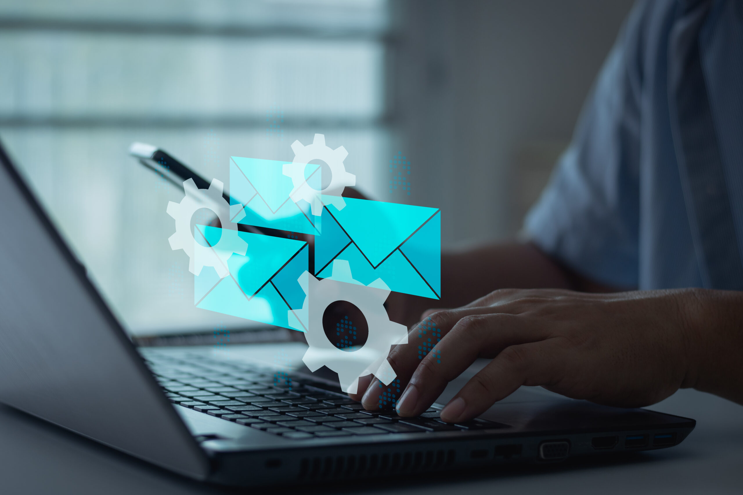 The image features a person using a laptop with digital illustrations of gears and envelopes floating above their hands, symbolizing the use of AI tools to optimize email campaigns. The gears represent automation or mechanics of the system, while the envelopes suggest communication or email marketing. The overall theme suggests enhancing email marketing strategies through automation and AI technology.